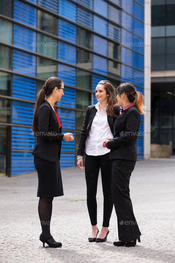 Three Businesswomen outdoors talking.