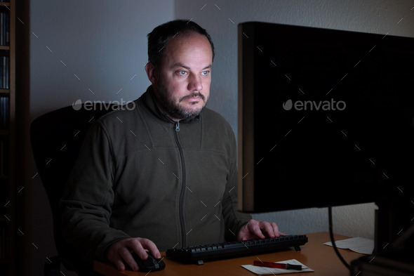 man sitting in front of computer at night