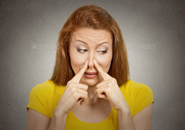 woman pinches nose with fingers something stinks