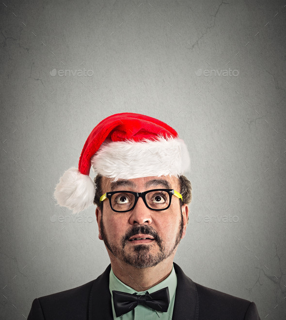 xmas man with glasses in red santa claus hat looking up