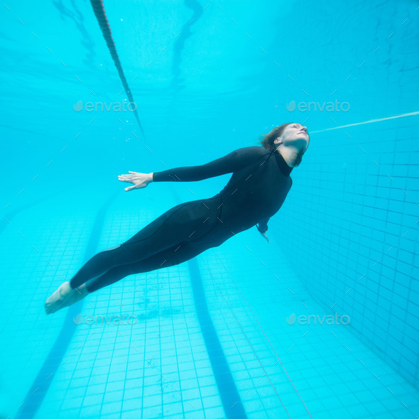 Female diver flying underwater in swimming pool