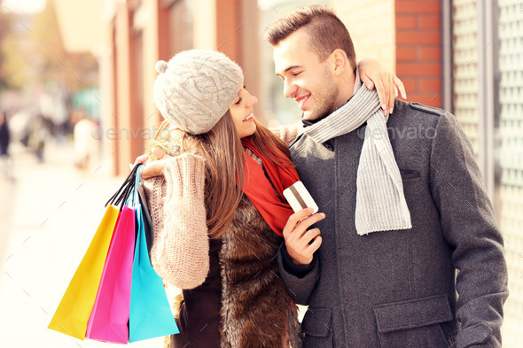 Young couple with credit card shopping in the city