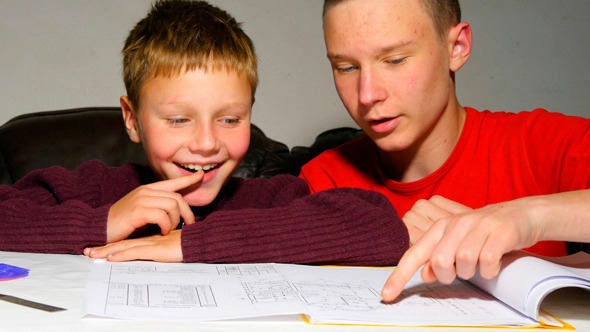 Teen Explaining Architectural Plan To His Brother Teen Explaining Architectural Plan To His Brother