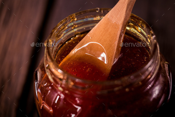 Honey dripping from a wooden honey dipper on black background (Misc) Photo Download