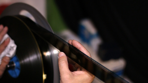 Film Technician Rewinding and Checking 35mm Film Film Technician Rewinding and Checking 35mm Film