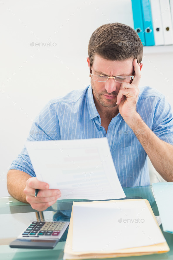 Businessman reading document at his desk in his office in his office (Misc) Photo Download