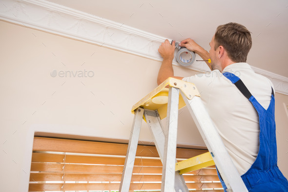 Handyman putting scotch on the ceiling in a new house (Misc) Photo Download