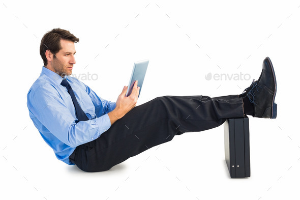 Businessman sitting using tablet with feet on his briefcase (Misc) Photo Download