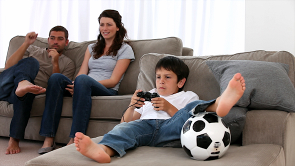 Cute Little Boy Playing Video Games and Parents Enjoying Watching Cute Little Boy Playing Video Games and Parents Enjoying Watching
