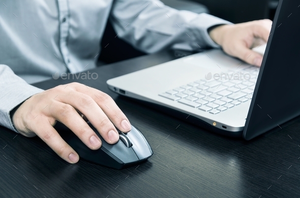 Man using laptop with white keyboard. Working in office