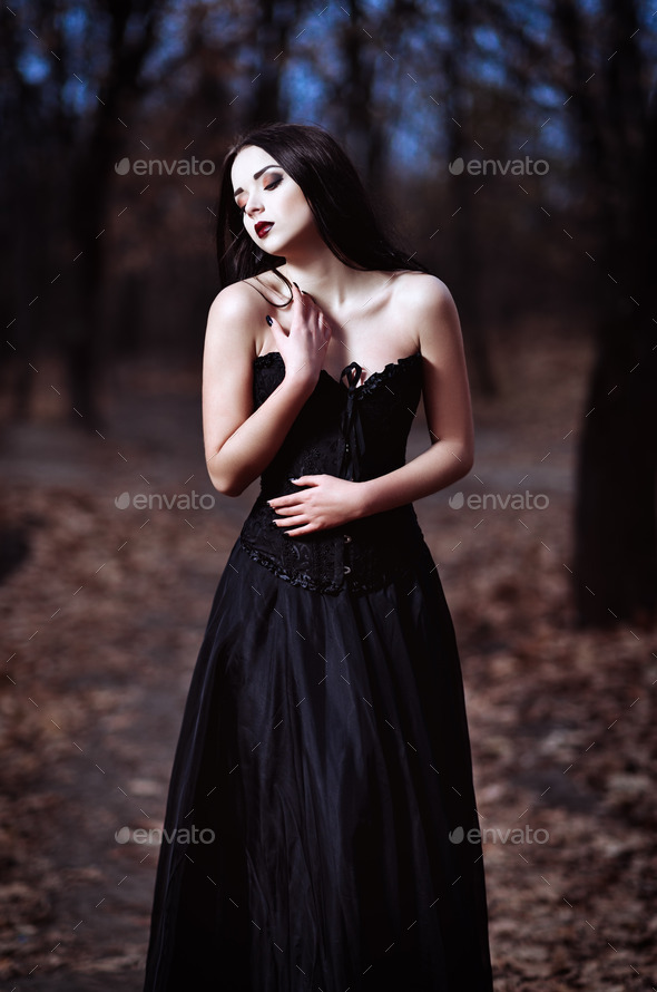 A beautiful sad goth girl stands in grove (Misc) Photo Download