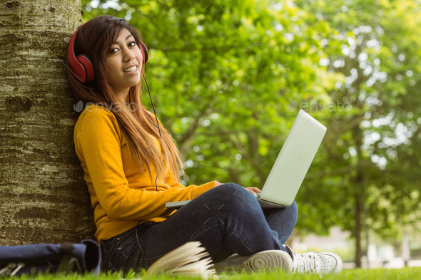 Side view portrait of relaxed young woman using laptop in the park (Misc) Photo Download