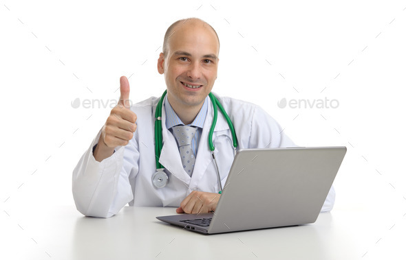 handsome doktor sitting at a desk with laptop (Misc) Photo Download