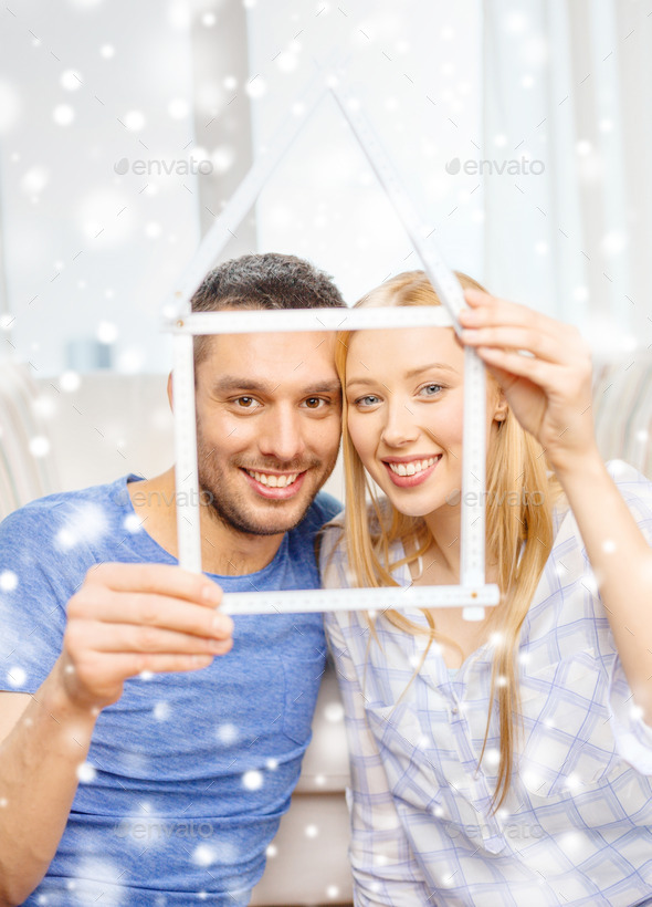 smiling couple holding house model at home (Misc) Photo Download