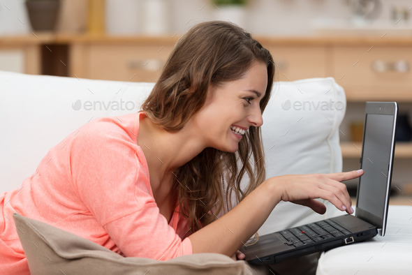 Smiling woman reading information on her laptop
