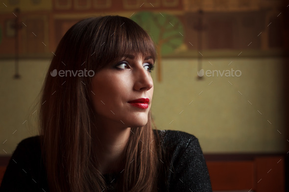 Young beautiful woman looking into window in restaurant