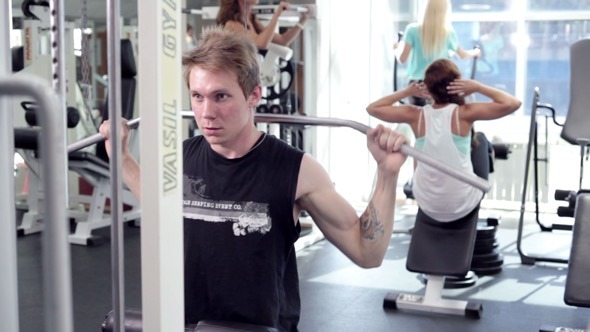 Young Man Uses Lat Machine Young Man Uses Lat Machine