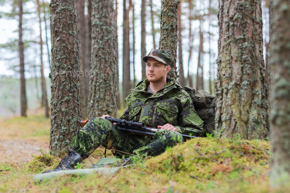young soldier or hunter with gun in forest (Misc) Photo Download