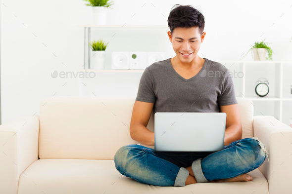 young Man sitting in sofa and using laptop