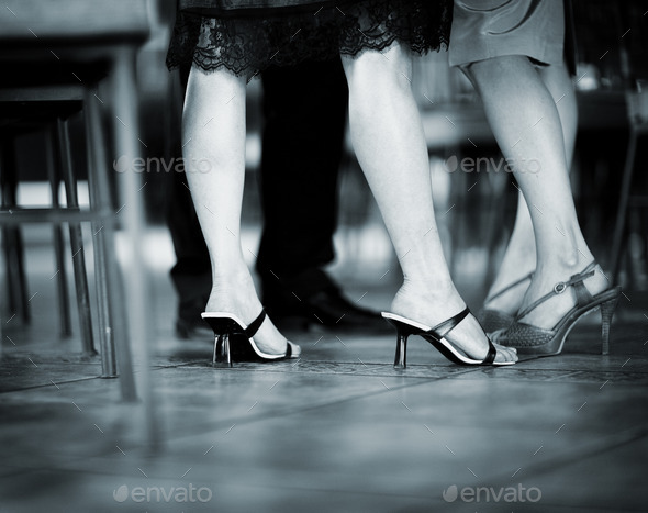 Feet of female wedding guests in heel shoes in party