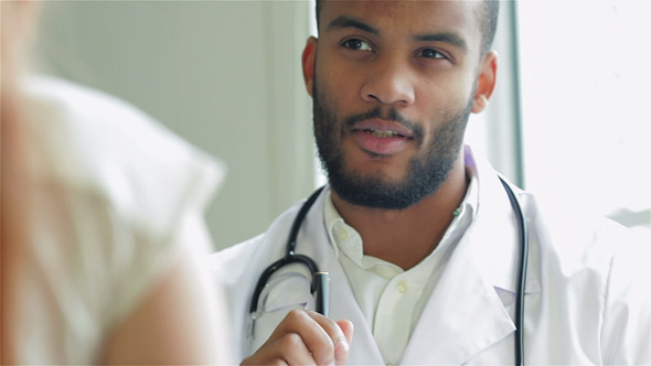 Smiling Doctor Showing A Patient A Drug Smiling Doctor Showing A Patient A Drug