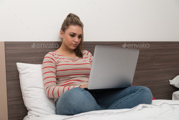 Happy Student On Bed Using Laptop