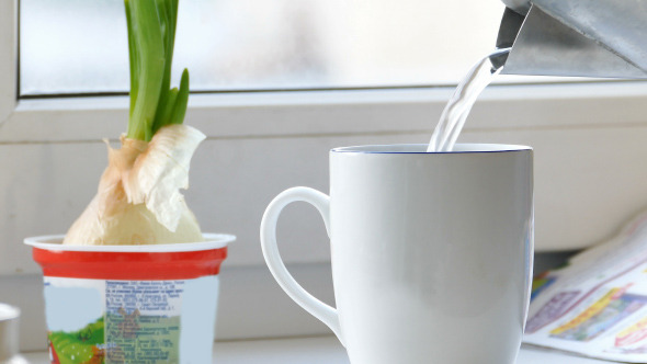 Pouring Tea to Cup From Steel Electric Teapot Pouring Tea to Cup From Steel Electric Teapot
