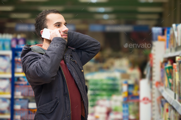 Handsome Man On Mobile Phone At Supermarket