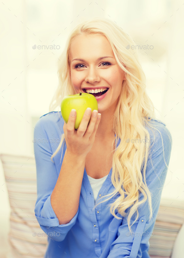 smiling woman with green apple at home (Misc) Photo Download