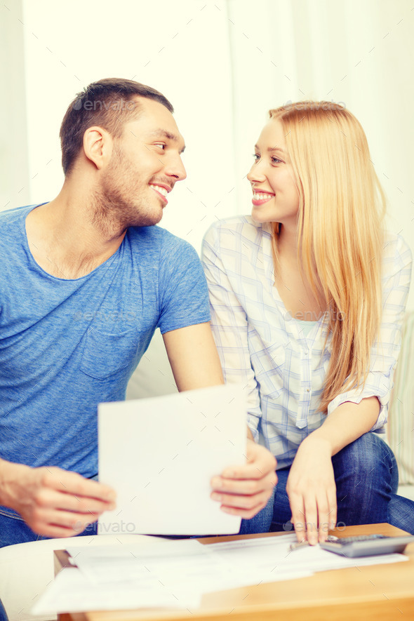 smiling couple with papers and calculator at home (Misc) Photo Download