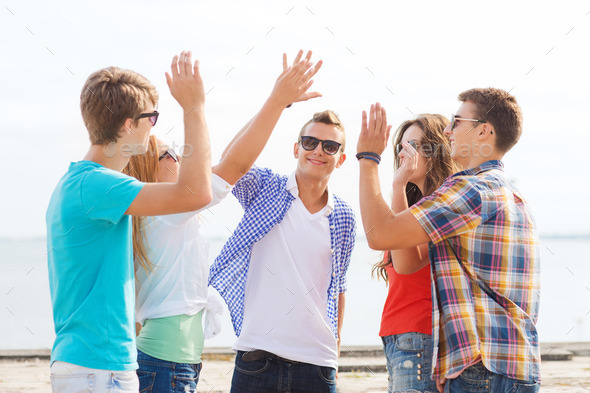 group of smiling friends making high five outdoors (Misc) Photo Download