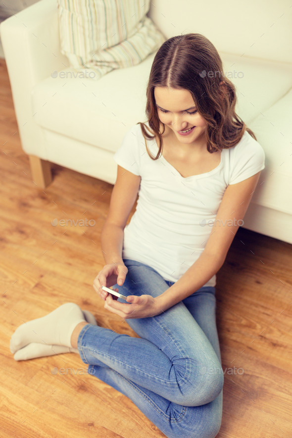 smiling teenage girl with smartphone at home (Misc) Photo Download