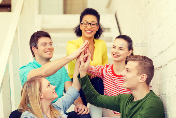 smiling students making high five gesture sitting (Misc) Photo Download