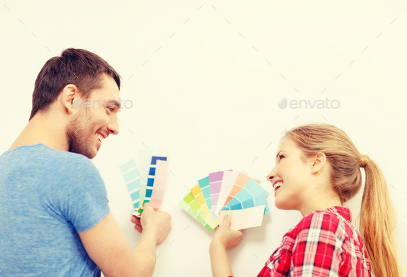 smiling couple looking at color samples at home (Misc) Photo Download