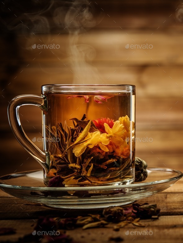 Glass cup with tea flower against wooden background (Misc) Photo Download