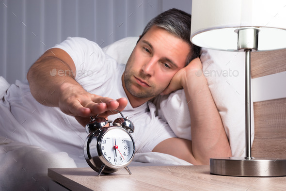 Man Snoozing Alarm Clock
