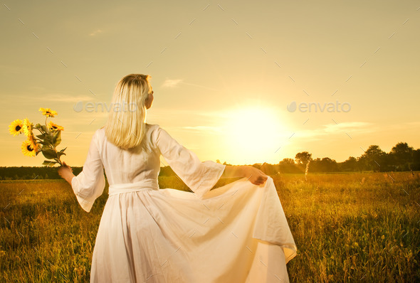 Beautiful woman with sunflowers in the field at sunset (Misc) Photo Download