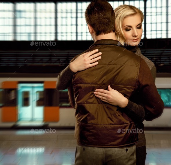 Beautiful couple embracing on train station (Misc) Photo Download