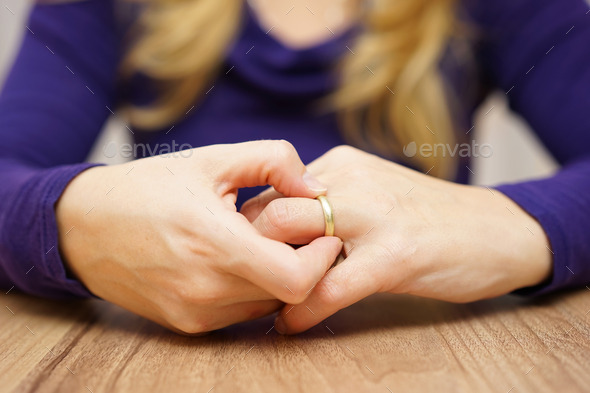 Woman is taking off the wedding ring