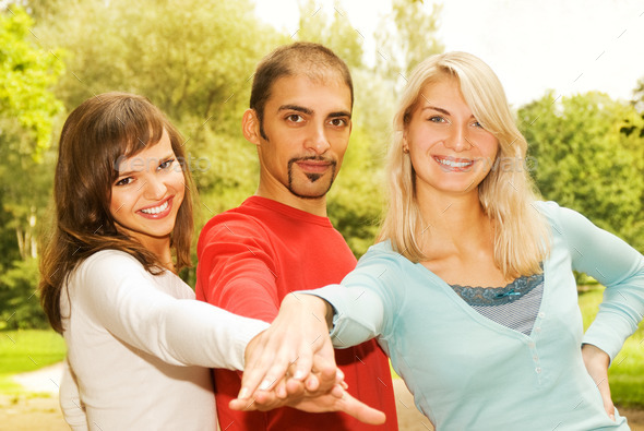 Group of young people put hands on top of each other (Misc) Photo Download