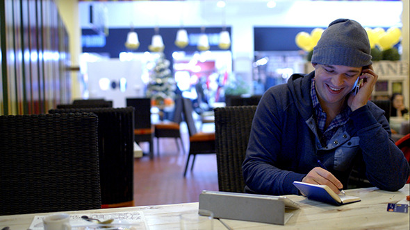 VideoHive Young Man In Cafe Speaks Phone And Writes Down 10151109 VideoHive Young Man In Cafe Speaks Phone And Writes Down 10151109