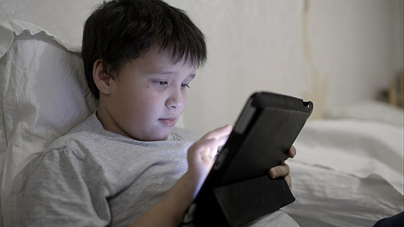 VideoHive Teenager Boy Using Tablet Computer Lying In Bed 10151552 VideoHive Teenager Boy Using Tablet Computer Lying In Bed 10151552