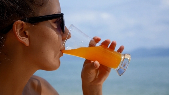 VideoHive Woman Drinking Juice against Sea 10158902 VideoHive Woman Drinking Juice against Sea 10158902