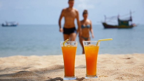 Couple Resting on the Beach with Cocktails Couple Resting on the Beach with Cocktails