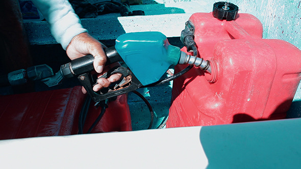 Man Fueling Tank Of A Motor Boat Before Travel Man Fueling Tank Of A Motor Boat Before Travel