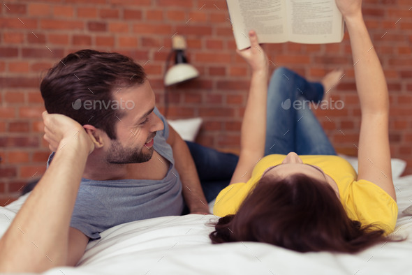 Husband watching his wife read a book