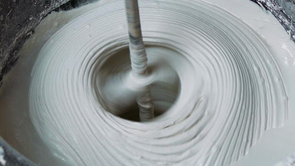 Rotating Whisk Mixer Immersed in Plaster Mix Rotating Whisk Mixer Immersed in Plaster Mix