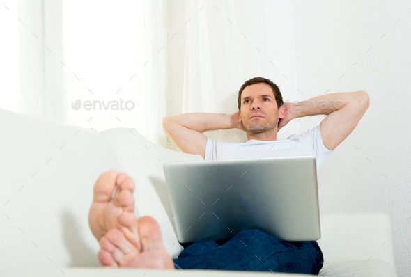 happy attractive man freelance working with computer laptop layi