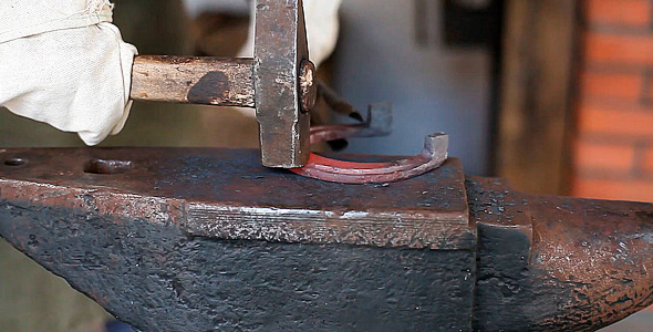 Blacksmith Forges a Horseshoe in a Smithy Blacksmith Forges a Horseshoe in a Smithy