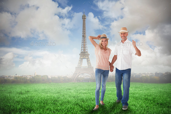 Happy couple walking holding hands against eiffel tower (Misc) Photo Download